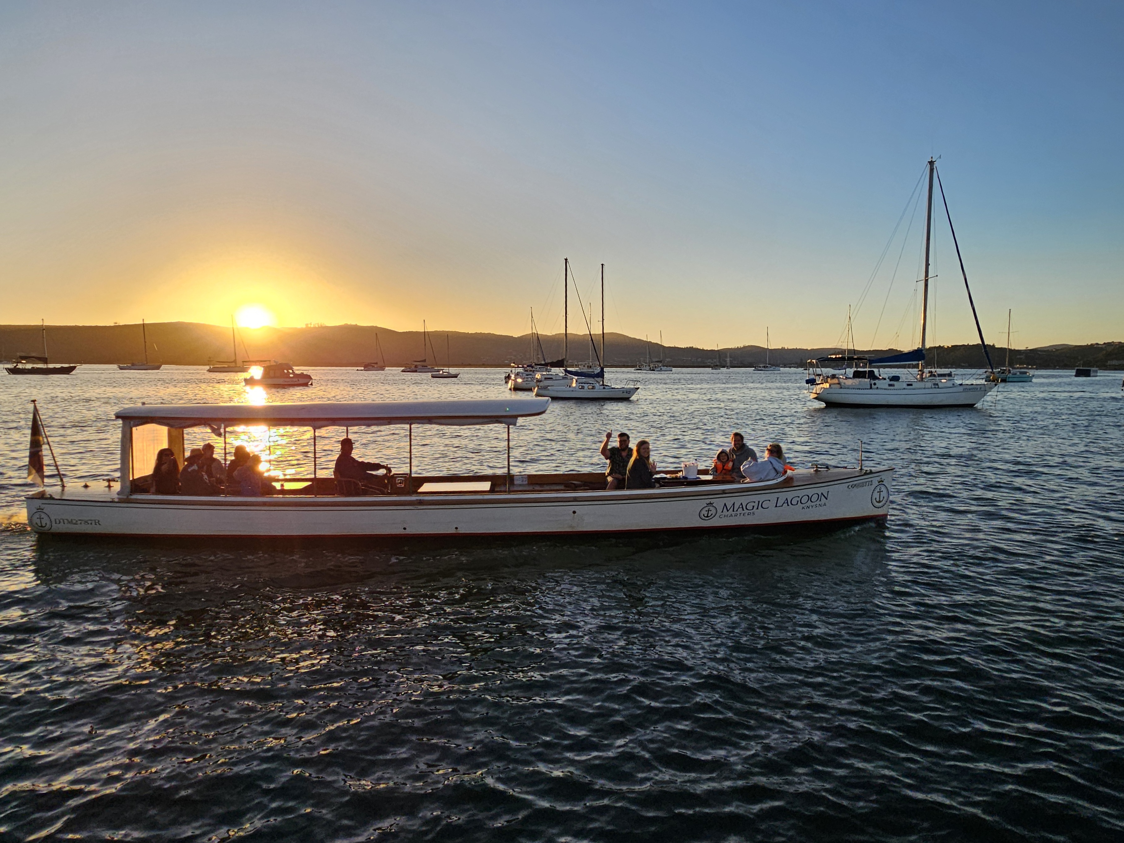 Coquette mahogany boat on the Knysna Lagoon — fun, social sunset cruise for groups